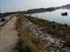 A sea wall that stops the sea coming into an estuary so it can be drained and reclaimed
